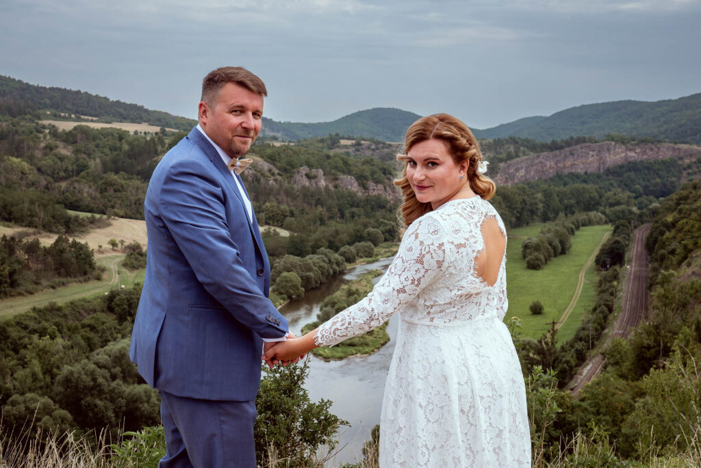 Ženich a nevěsta na vyhlídce s výhledem do krajiny